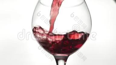 玫瑰酒。 红酒倒在白色背景上的酒杯里。 慢动作